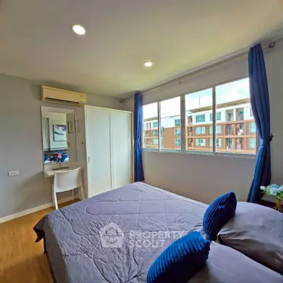 Cozy bedroom with large window and modern decor in urban apartment