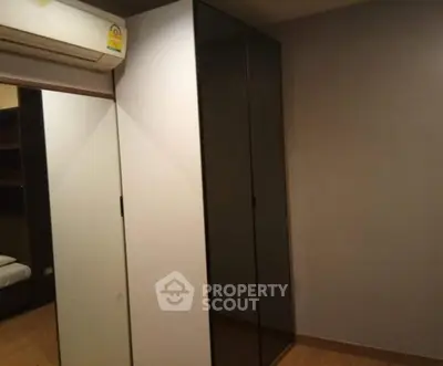 Modern bedroom with sleek wardrobe and air conditioning unit