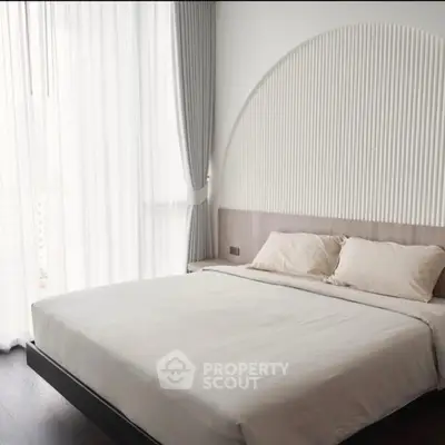 Modern bedroom with elegant design and large window for natural light.