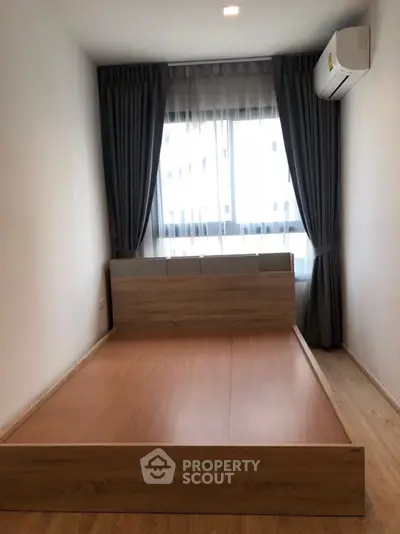 Modern minimalist bedroom with wooden flooring and large window