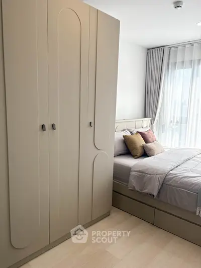 Modern bedroom with sleek wardrobe and cozy bed near large window