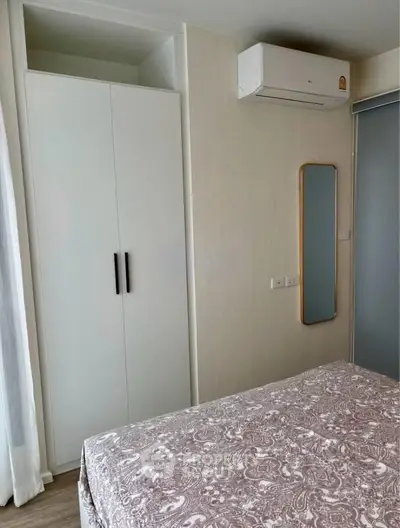 Cozy bedroom with air conditioning and stylish wardrobe in modern apartment.