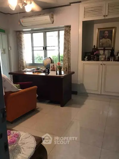 Cozy study room with desk, air conditioning, and decorative elements, perfect for work or relaxation.