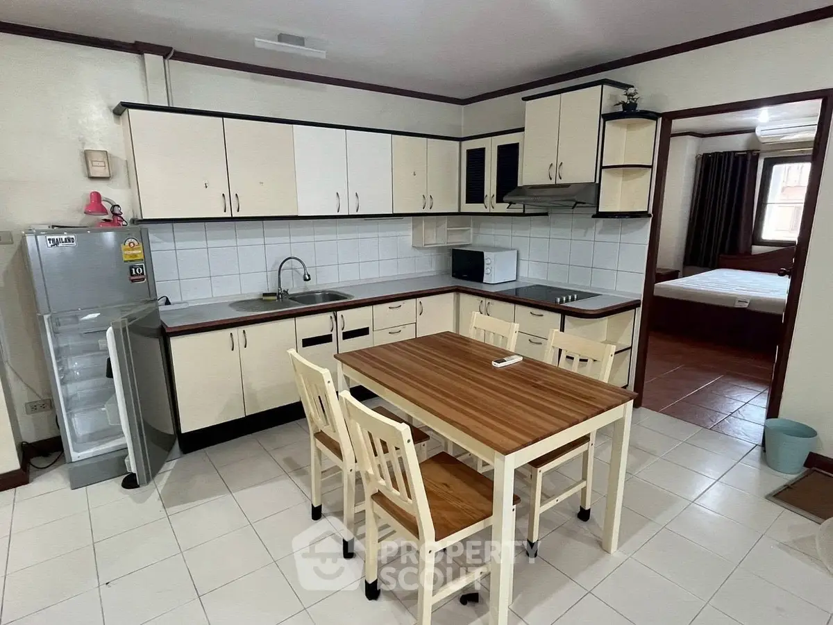 Spacious kitchen with dining area and modern appliances in a cozy apartment