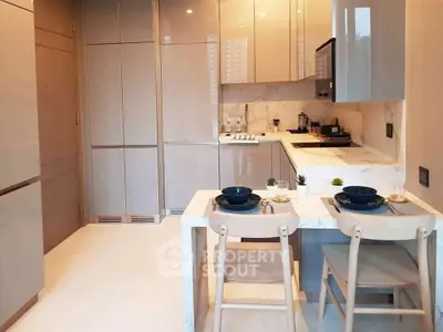 Modern kitchen with sleek cabinetry and dining area in stylish apartment