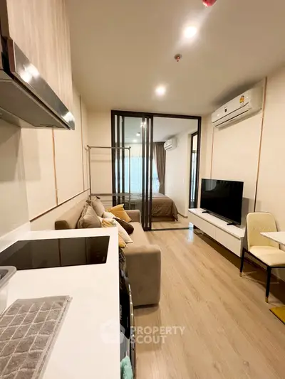 Modern open-plan living room with kitchen and bedroom in cozy apartment