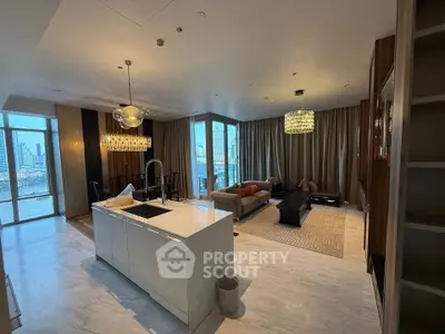 Luxurious open-plan living room with modern kitchen island and stunning city view.