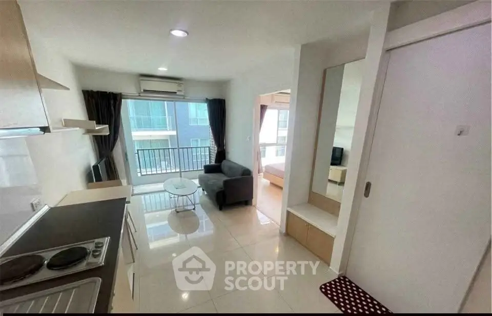 Modern apartment with open layout, featuring a cozy living area and balcony access, perfect for urban living.