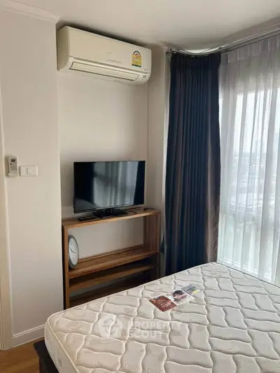 Modern bedroom with air conditioning and TV, featuring large window with curtains.
