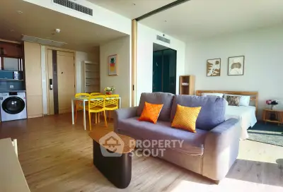 Modern open-plan living room with vibrant decor and integrated kitchen in a stylish apartment.