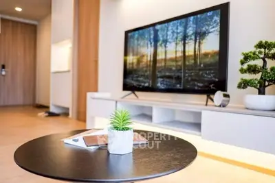 Modern living room with sleek TV and stylish decor, perfect for relaxation and entertainment.