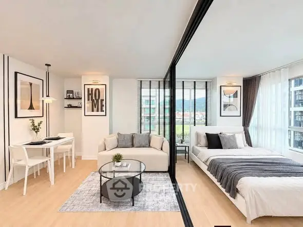 Modern studio apartment with open layout, featuring a cozy living area and stylish bedroom separated by glass partition.
