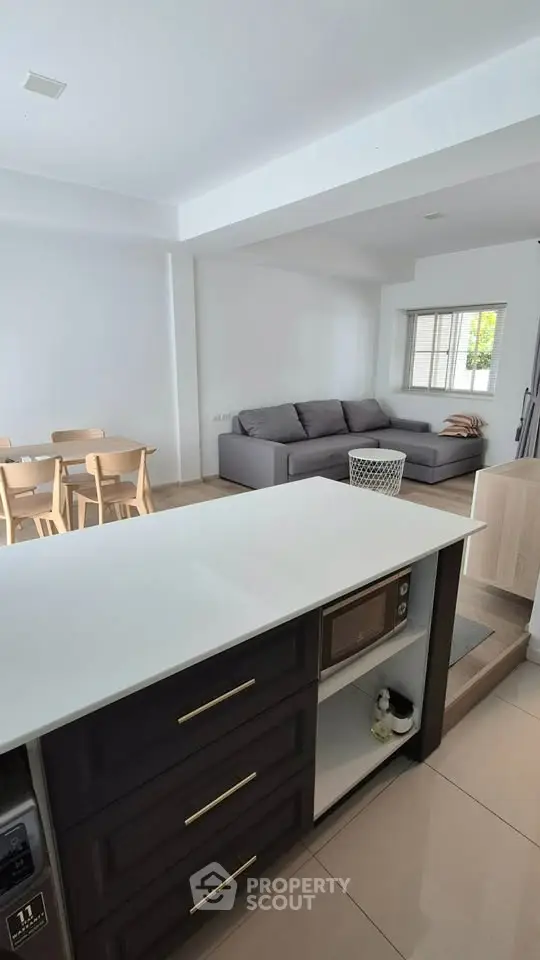 Modern open-plan kitchen and living room with sleek design and cozy seating area.