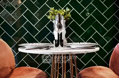 Chic dining setup with elegant tableware and lush green backdrop, perfect for intimate gatherings.