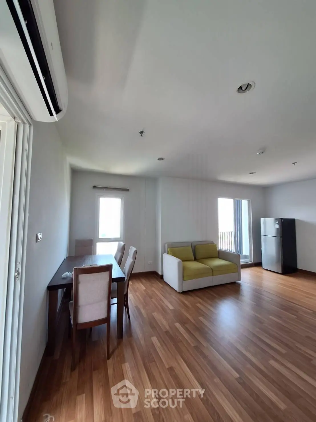 Spacious living room with modern dining area and large windows for natural light.