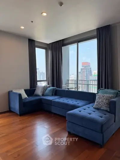 Spacious living room with modern blue sectional sofa and city view.