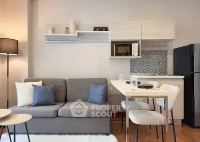 Modern living room with cozy sofa, stylish kitchen, and dining area in open layout apartment.
