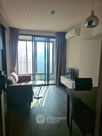 Modern living room with balcony and city view, featuring sleek furniture and natural light.