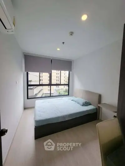 Modern bedroom with large window and minimalist design in urban apartment