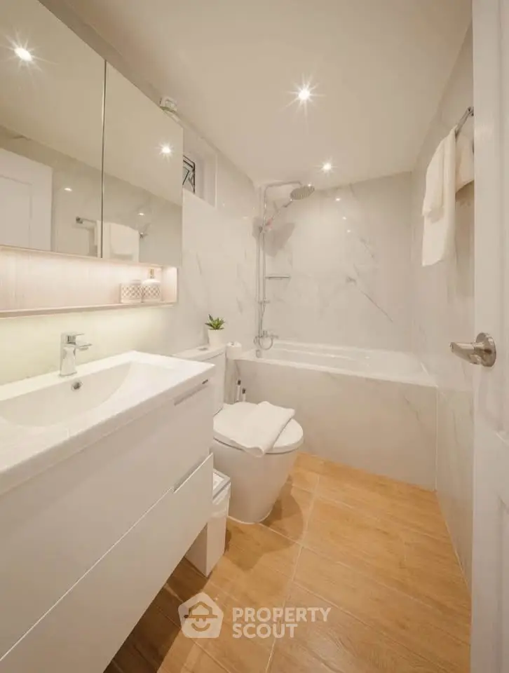 Modern bathroom with sleek fixtures and elegant marble tiles, featuring a bathtub and stylish vanity.