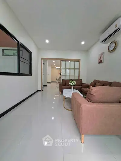 Spacious living room with modern furniture and air conditioning in a stylish home.