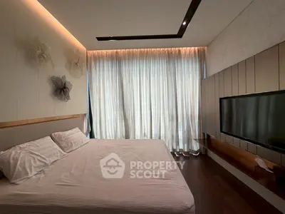 Luxurious bedroom with modern decor and large window for natural light
