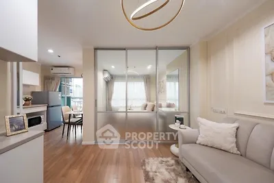 Modern living room with elegant decor and sliding glass doors leading to a cozy dining area.