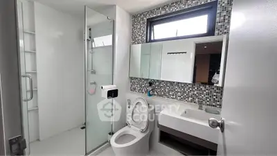 Modern bathroom with glass shower and mosaic tile accents