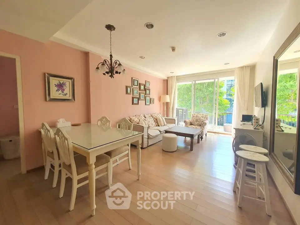 Charming living room with elegant decor and large windows offering natural light and garden view.