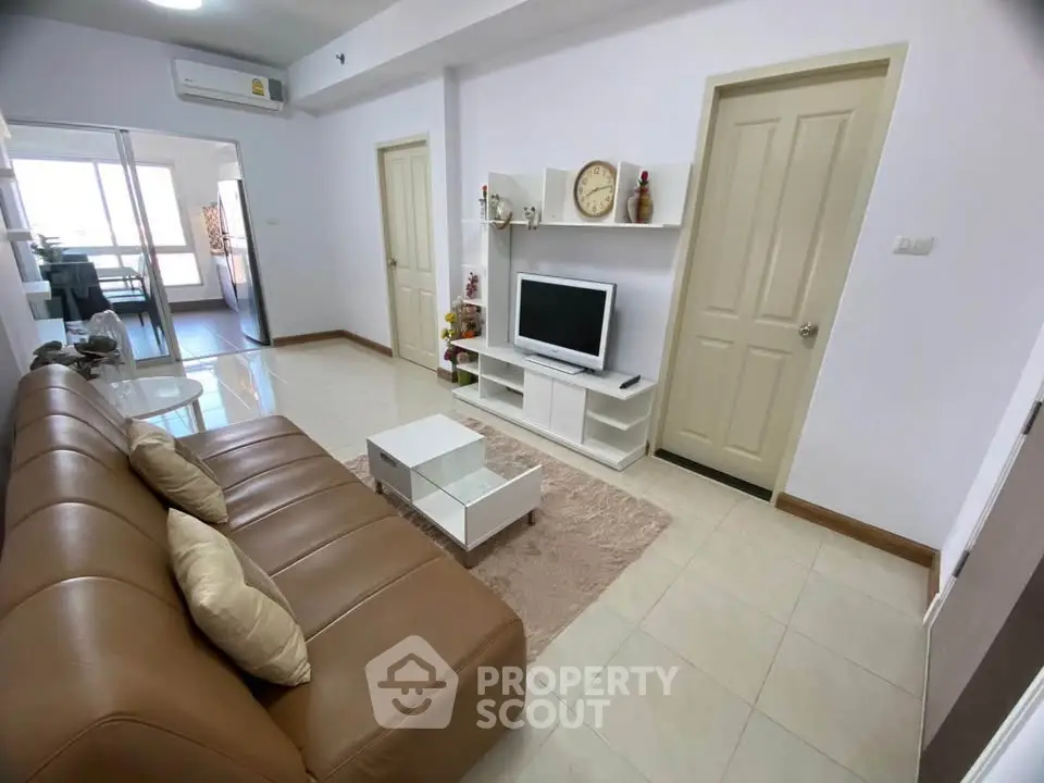Modern living room with sleek furniture and TV unit, perfect for relaxation.