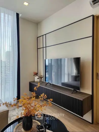 Modern living room with sleek TV setup and stylish decor, perfect for urban living.