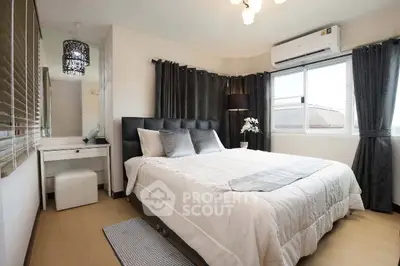 Modern bedroom with stylish decor, large window, and cozy ambiance.