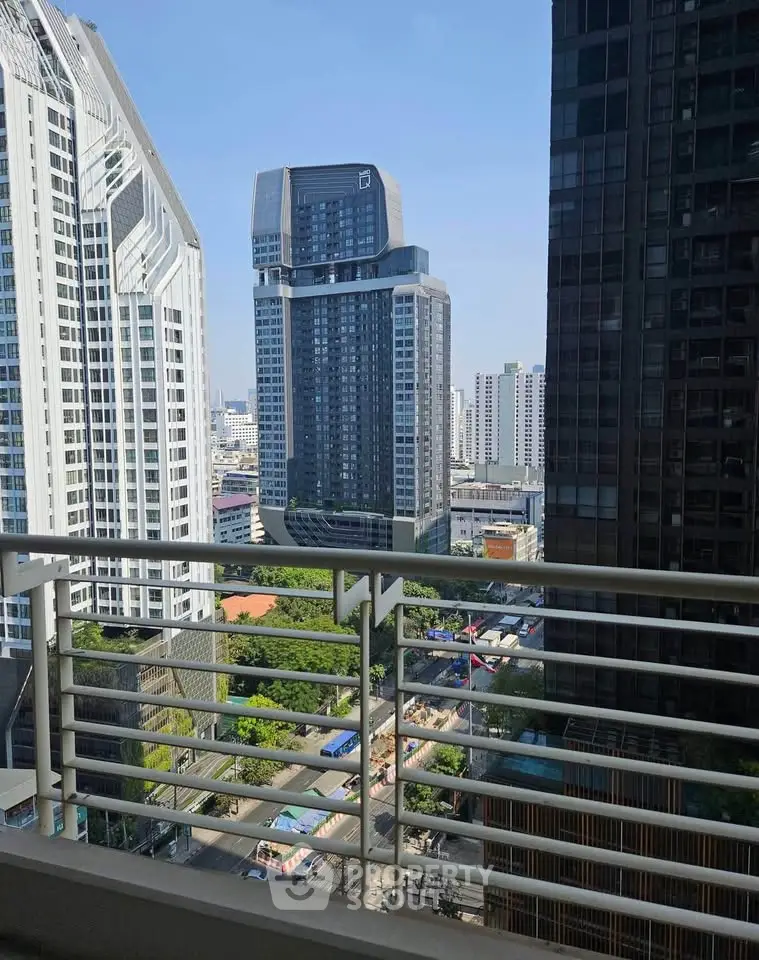 Stunning cityscape view from a high-rise balcony overlooking modern skyscrapers and lush greenery.