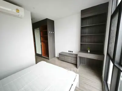 Spacious modern bedroom with built-in shelves and large window
