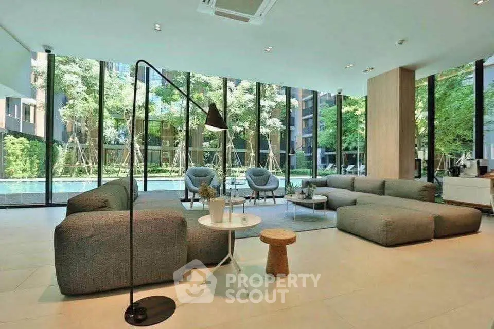 Luxurious modern living room with floor-to-ceiling windows and garden view, featuring stylish furniture.