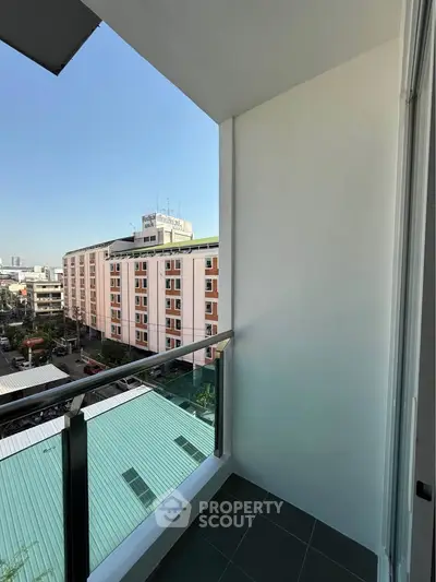Modern apartment balcony with city view and sleek railing design.