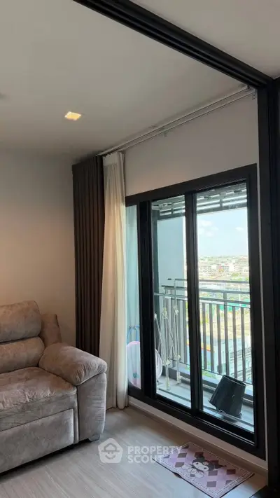 Modern living room with large window and balcony view in urban apartment