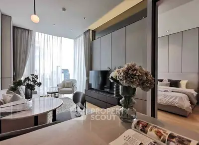 Modern open-plan living room with elegant decor and city view, connected to a cozy bedroom.