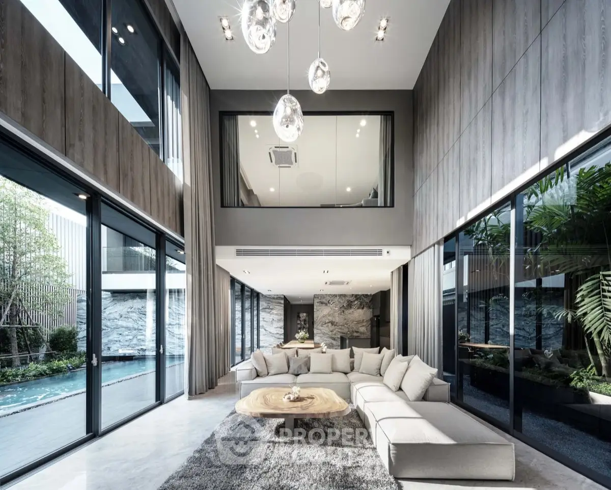 Luxurious modern living room with high ceilings and pool view