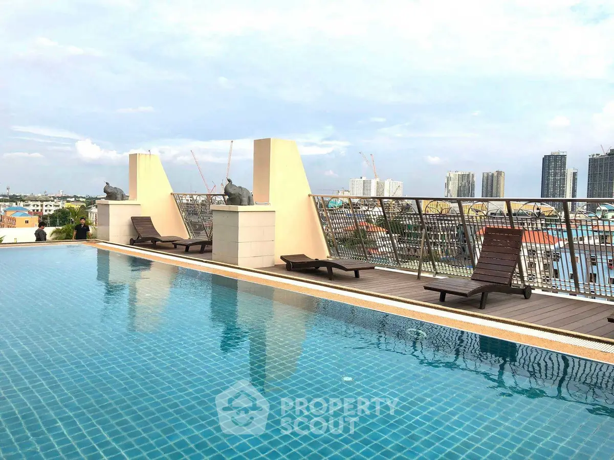 Luxurious rooftop pool with city skyline views and stylish lounge chairs.