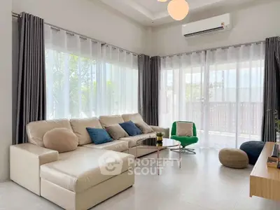Spacious modern living room with elegant furniture and large windows for natural light.