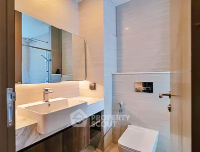 Modern bathroom with sleek fixtures and elegant design, featuring a stylish sink and contemporary toilet.