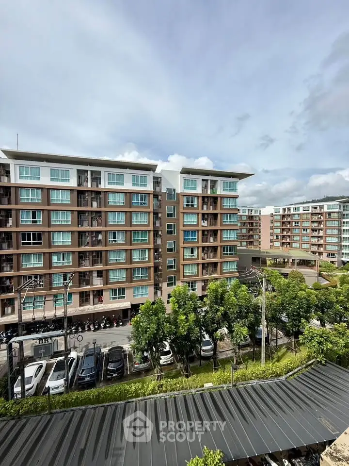 Modern apartment complex with lush greenery and ample parking space.