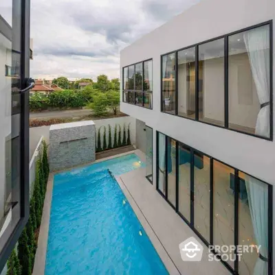 Modern luxury home with private pool and large windows offering stunning views.