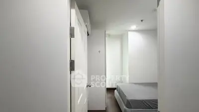 Minimalist bedroom with white walls and simple bed setup