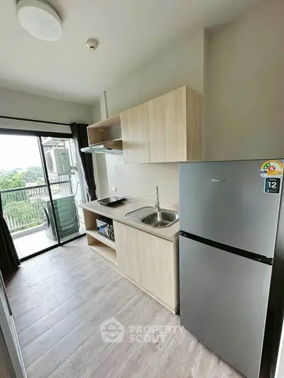 Modern compact kitchen with balcony view and sleek appliances