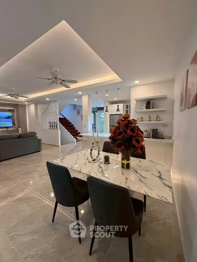 Luxurious open-plan living room with elegant marble dining table and modern decor