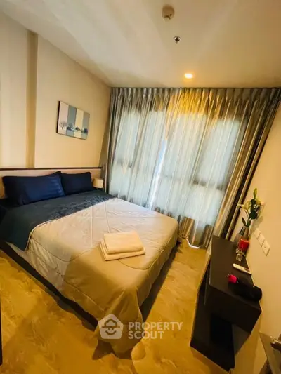 Cozy bedroom with large window and modern decor in a stylish apartment.