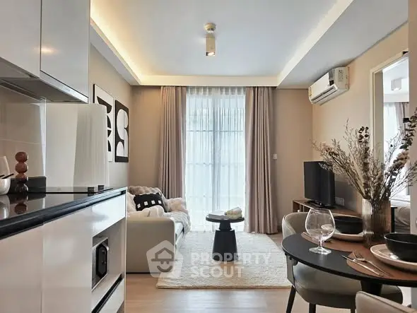 Modern living room with open kitchen, stylish decor, and natural light