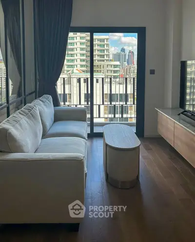 Modern living room with city view, cozy sofa, and sleek TV setup.